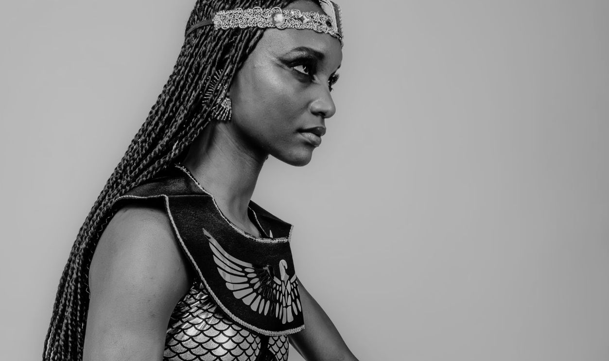 A woman in Egyptian-style costume poses elegantly, highlighting beauty and empowerment