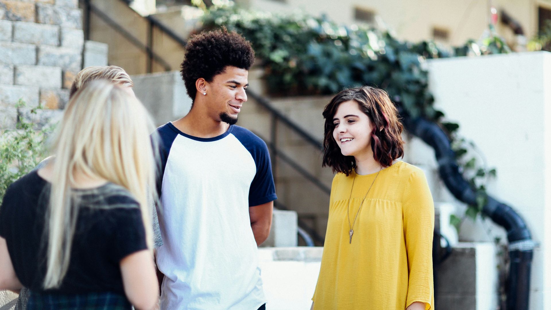 women and man talking outside the building