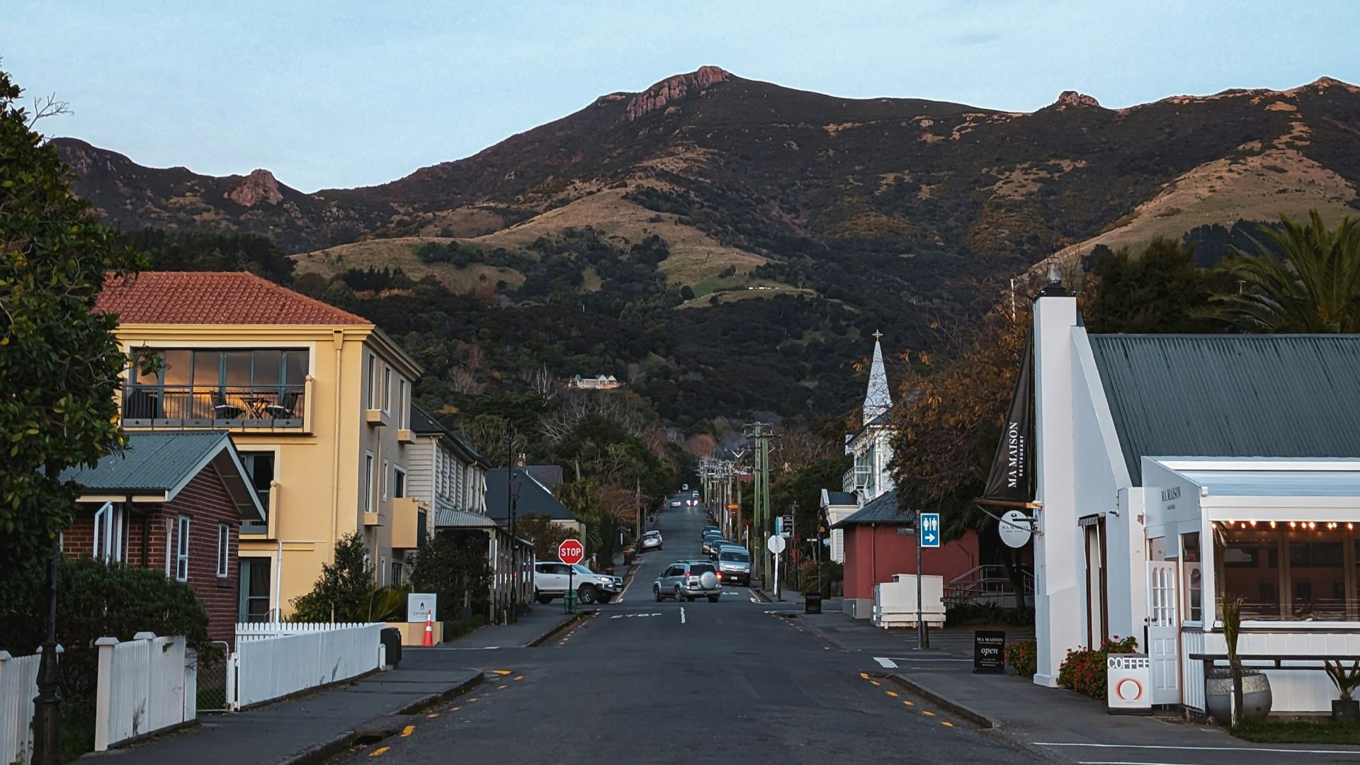 Street leading to mountains under a clear sky