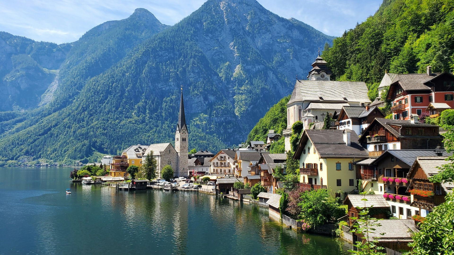 houses near body of water and mountain during daytime