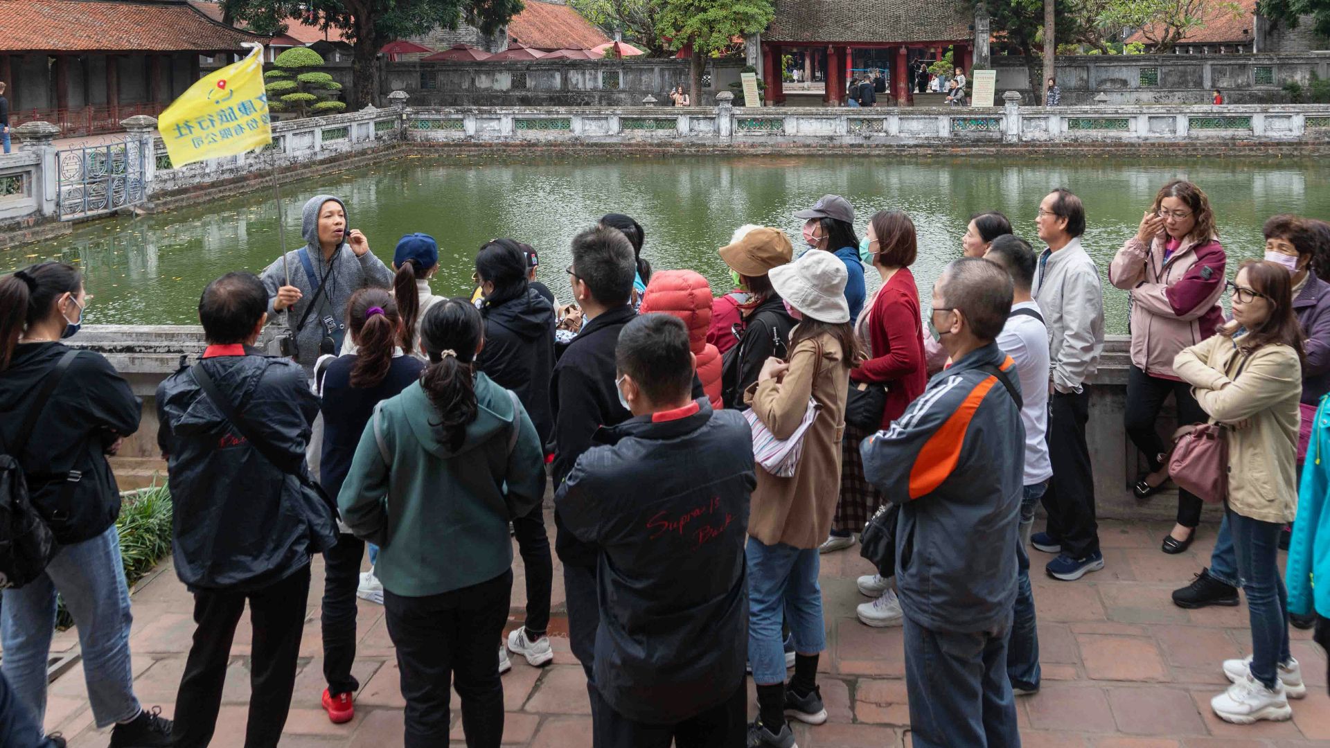 Tour group listens to guide by a pond