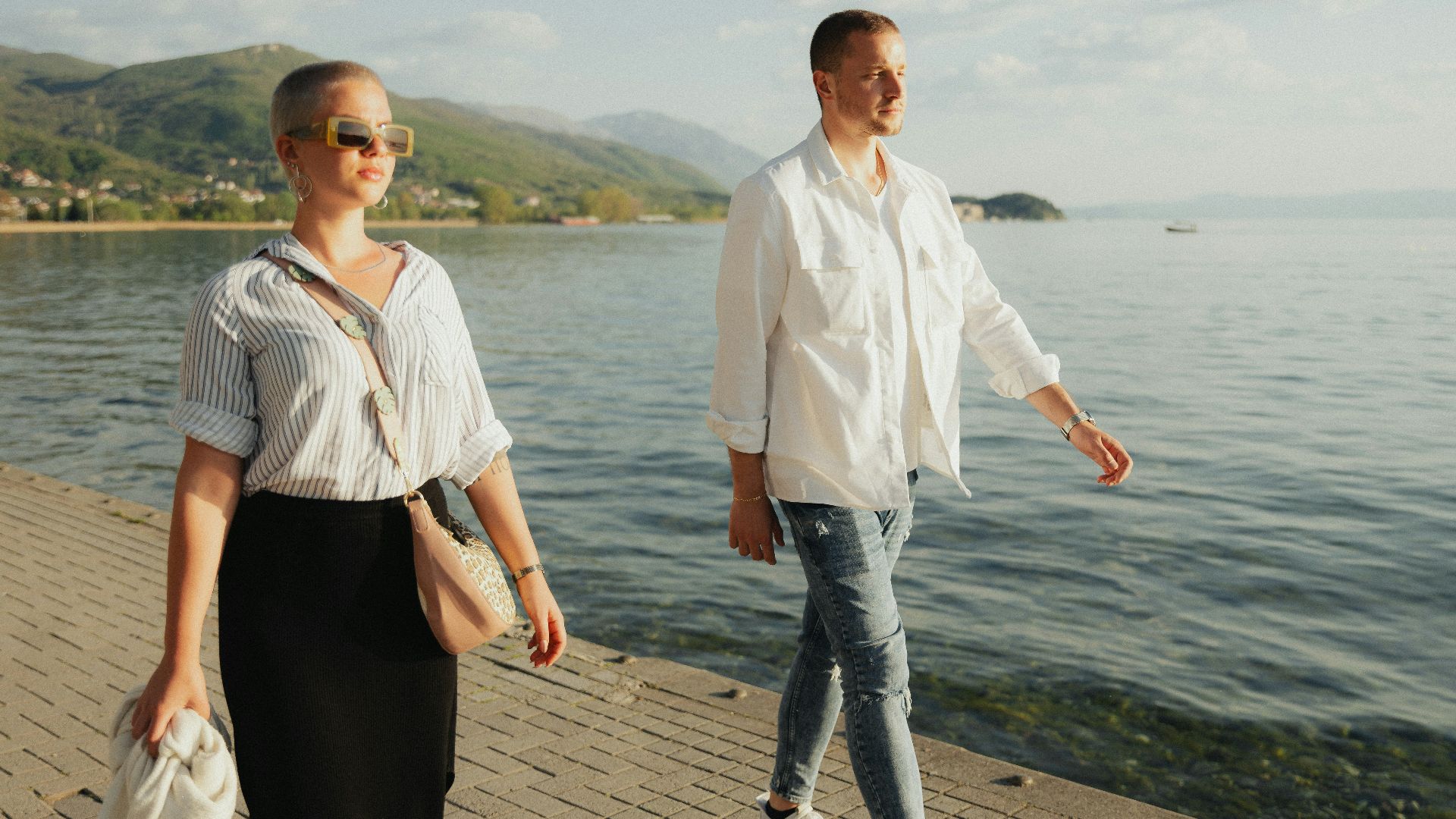 a man and a woman walking along a pier