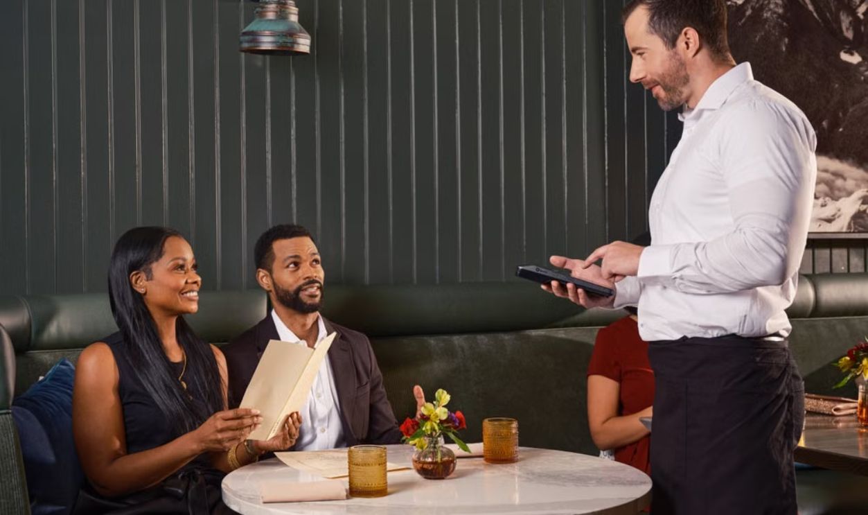 Couple dining in an upscale restaurant while using a digital ordering system for placing their order