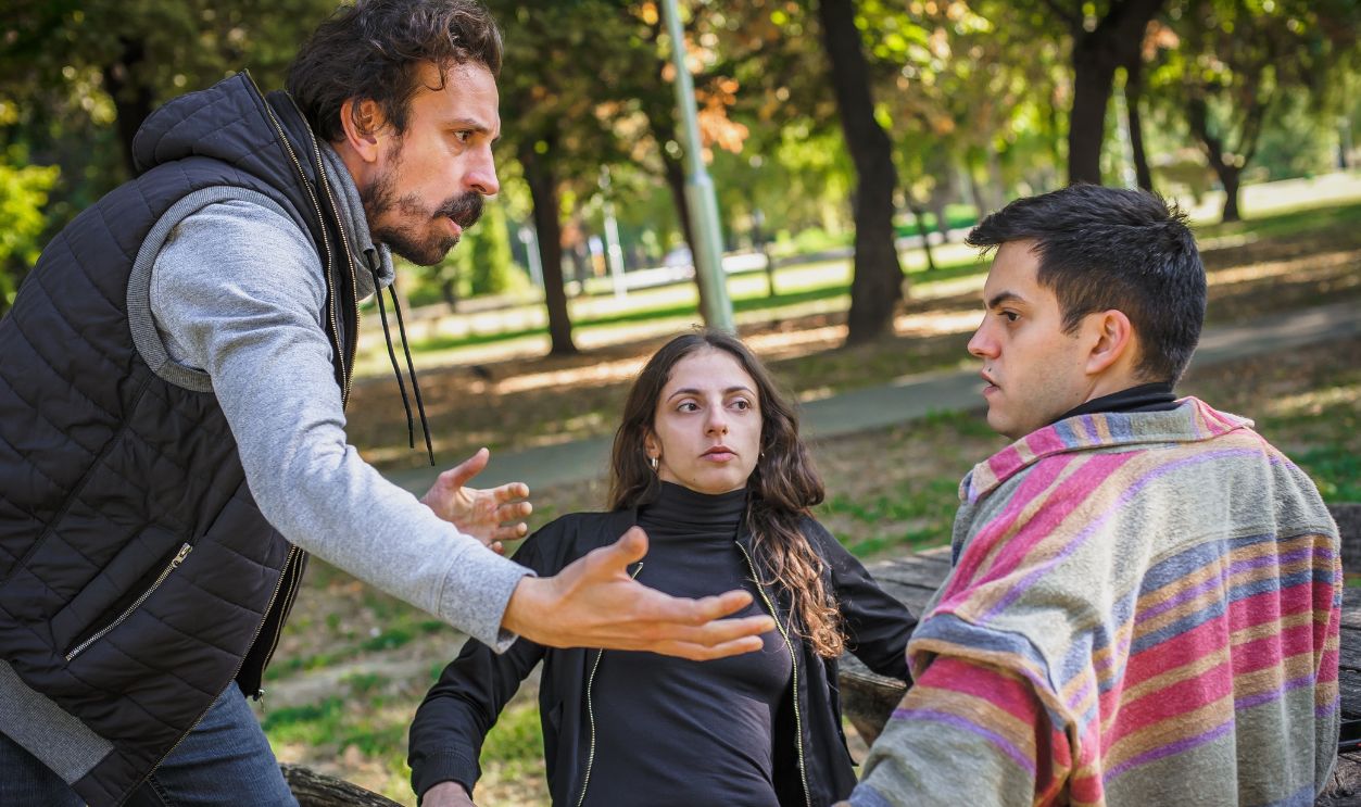 Three angry, nervous and upset friends, two men and a woman in a fierce argument. Group quarrel concept