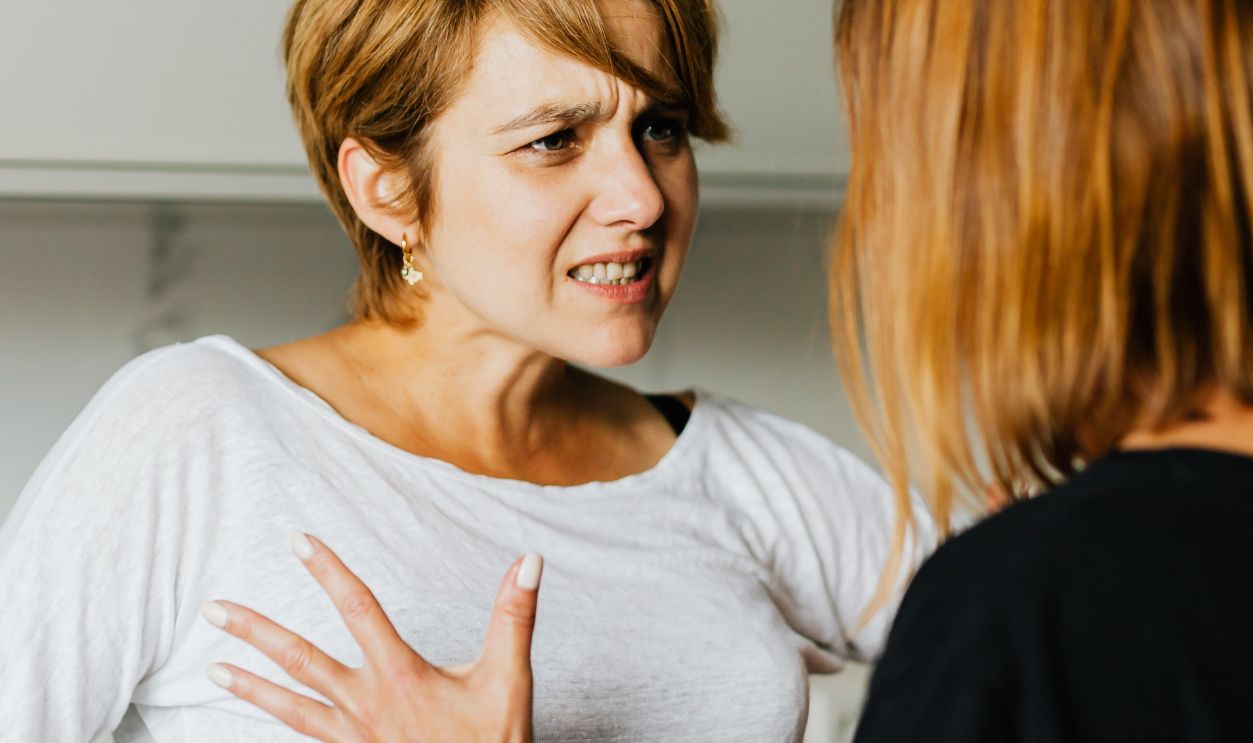 Two women engaged in a heated discussion in a modern kitchen
