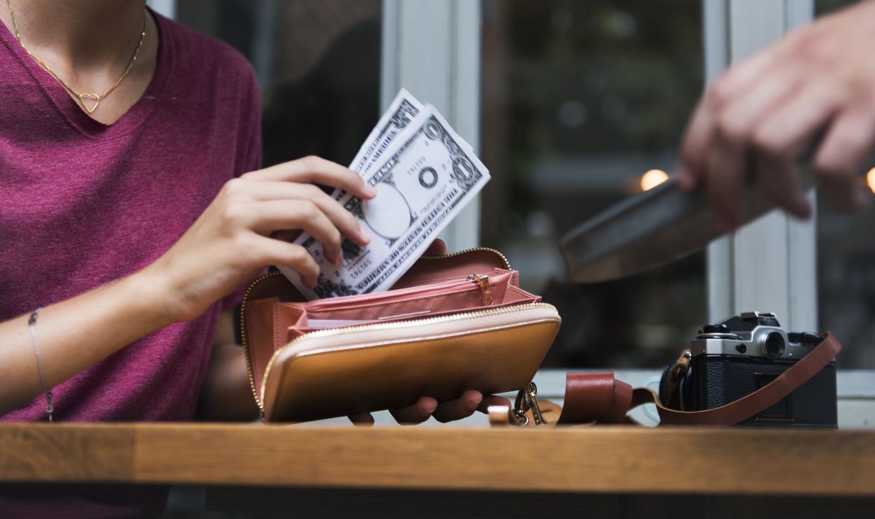Woman paying cash for bill restaurant