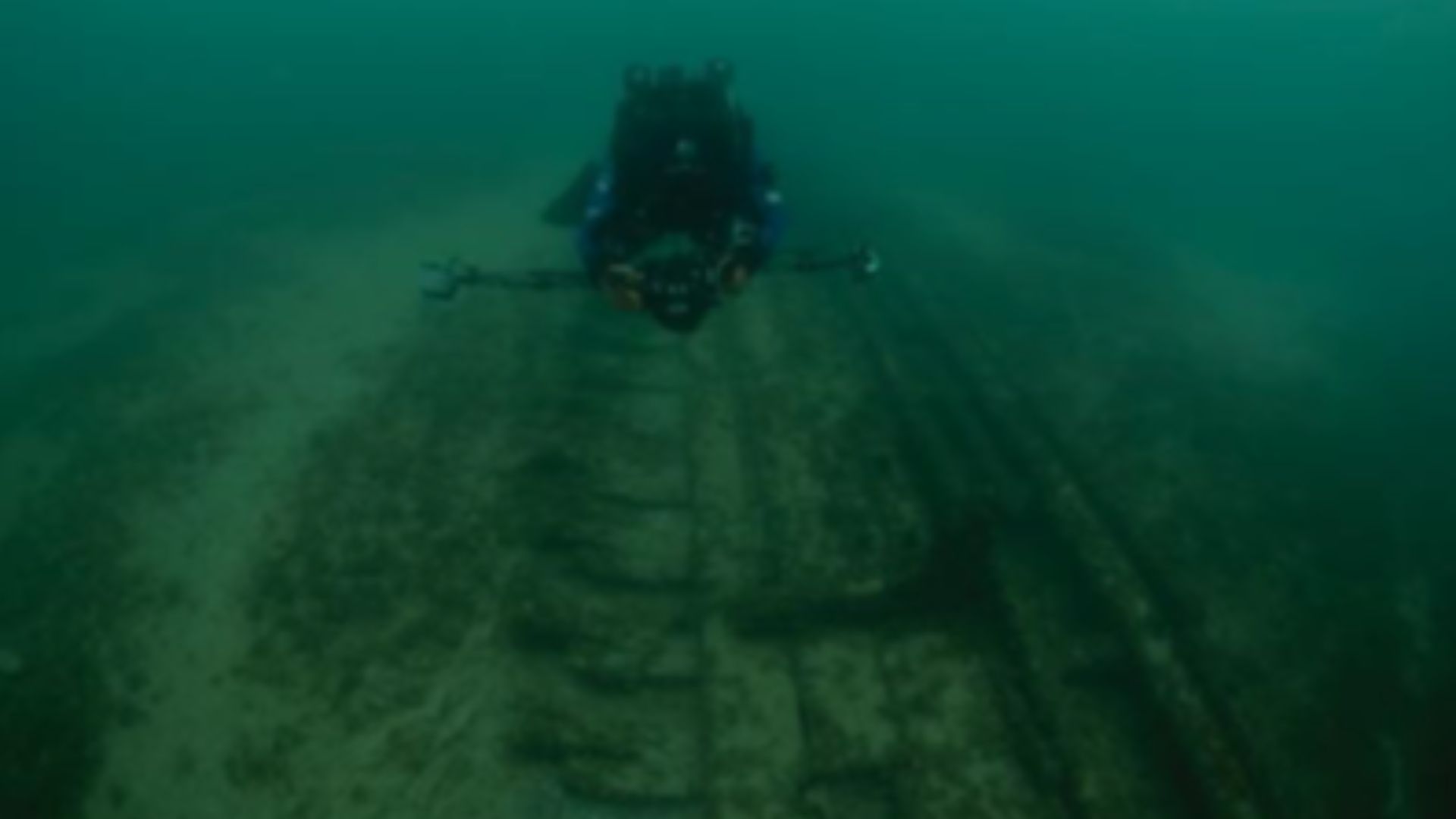 A scuba diver uses laser photogrammetry tools to record dimensions of a shipwreck in a National Marine Sanctuary.
