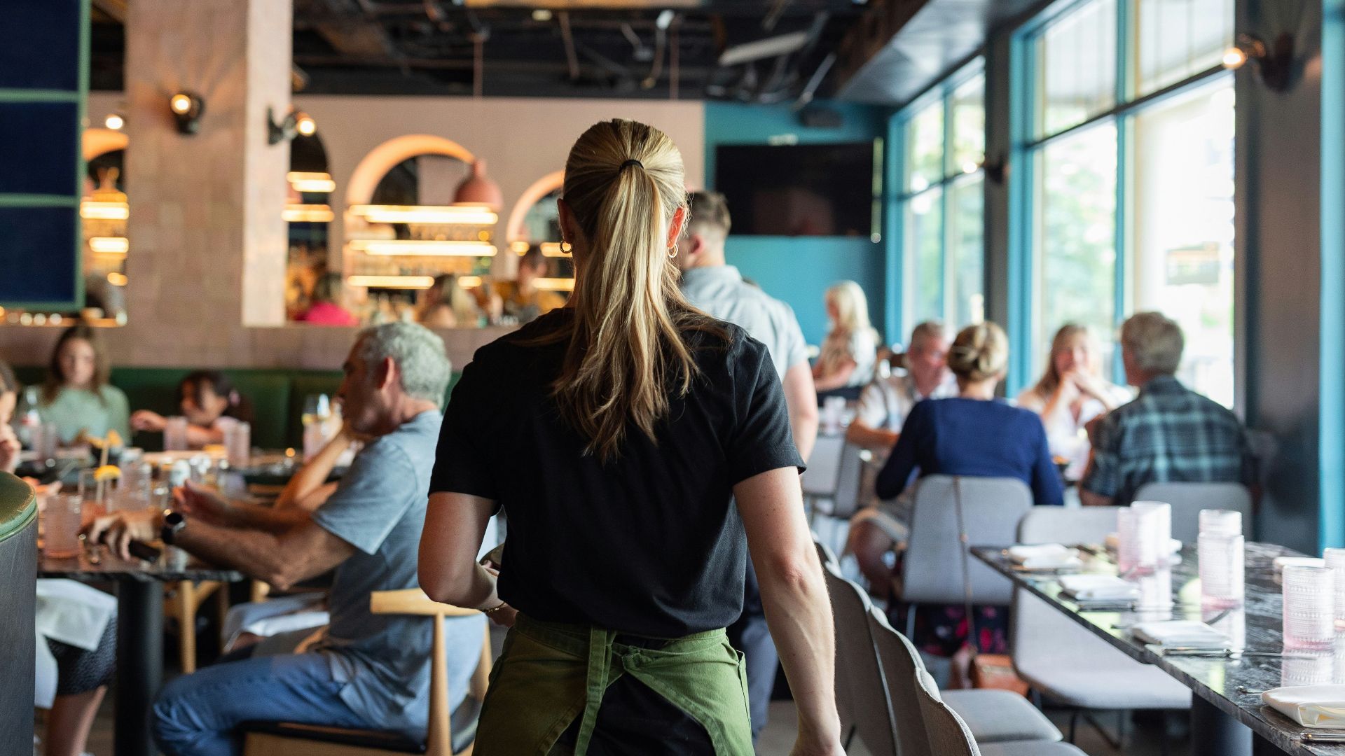 A group of people sitting at tables in a restaurant