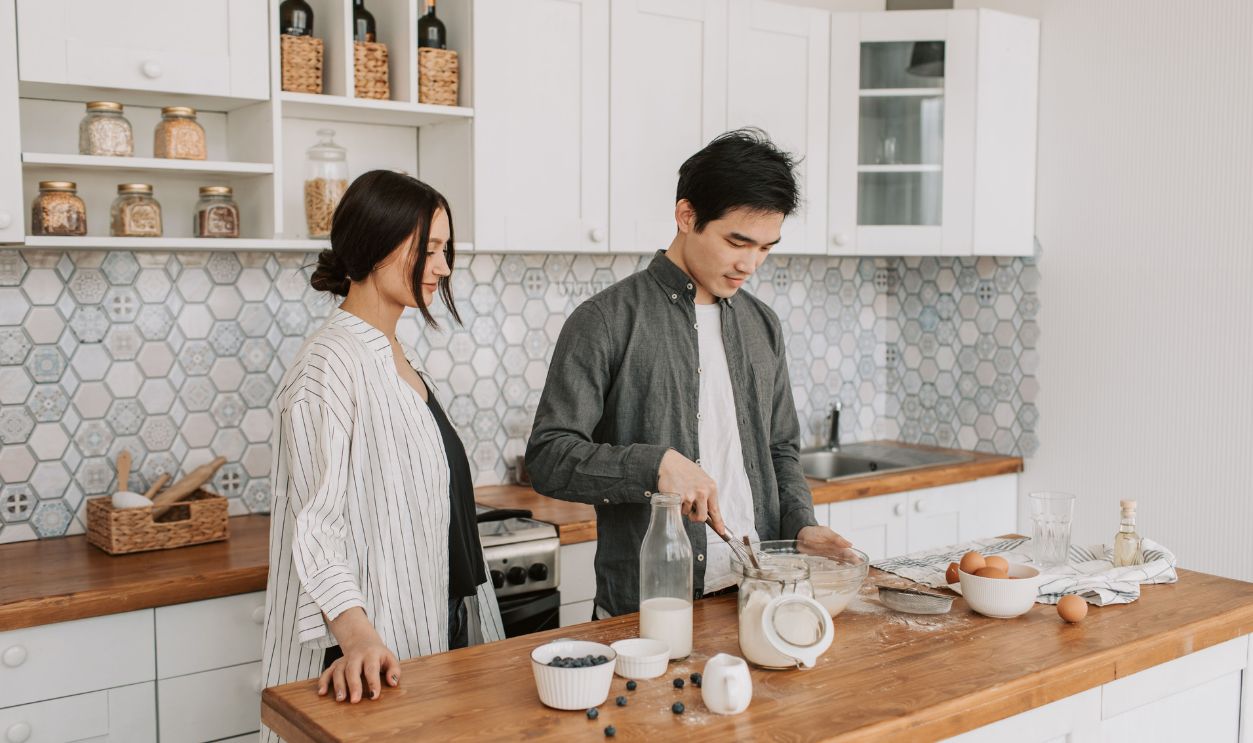 A couple in a modern kitchen preparing a meal together, showcasing teamwork