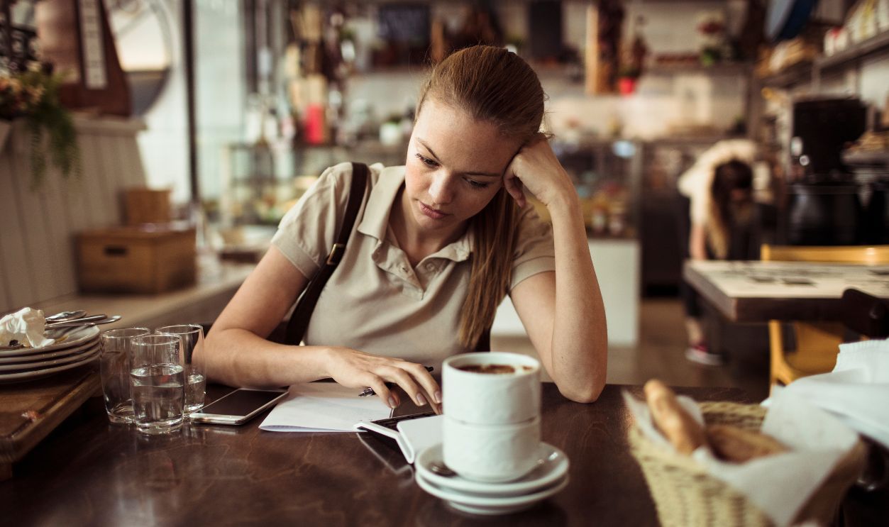 Waitress looking stressed while calculating bill at restaurant table
