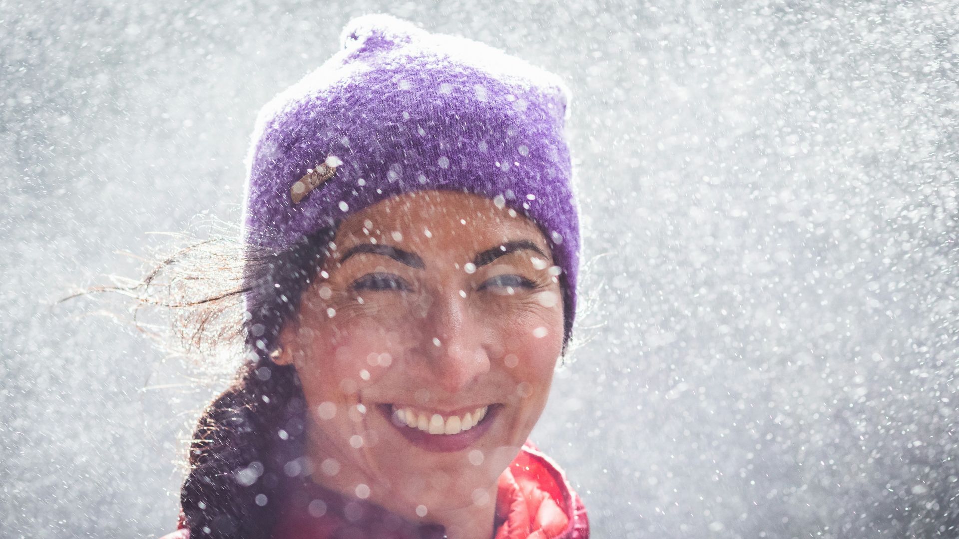 woman in red jacket and blue knit cap