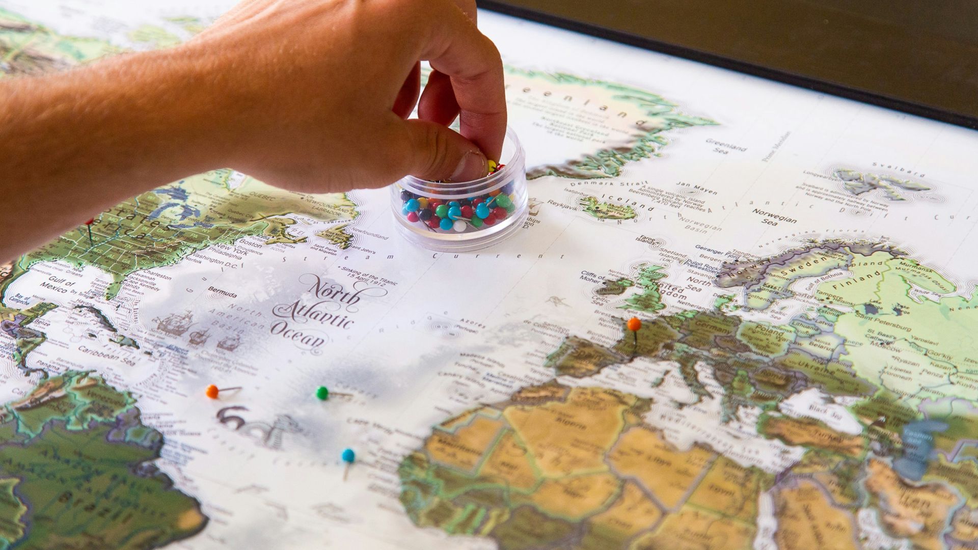 person holding silver ring on white and blue map