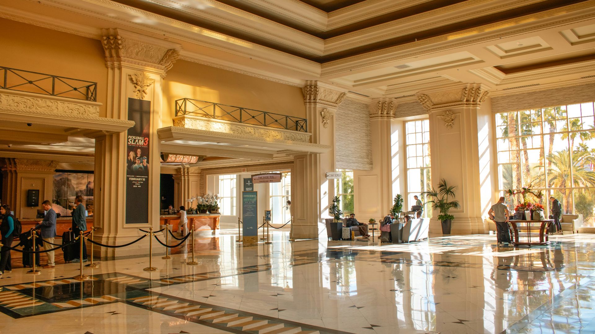 A grand hotel lobby filled with sunlight.