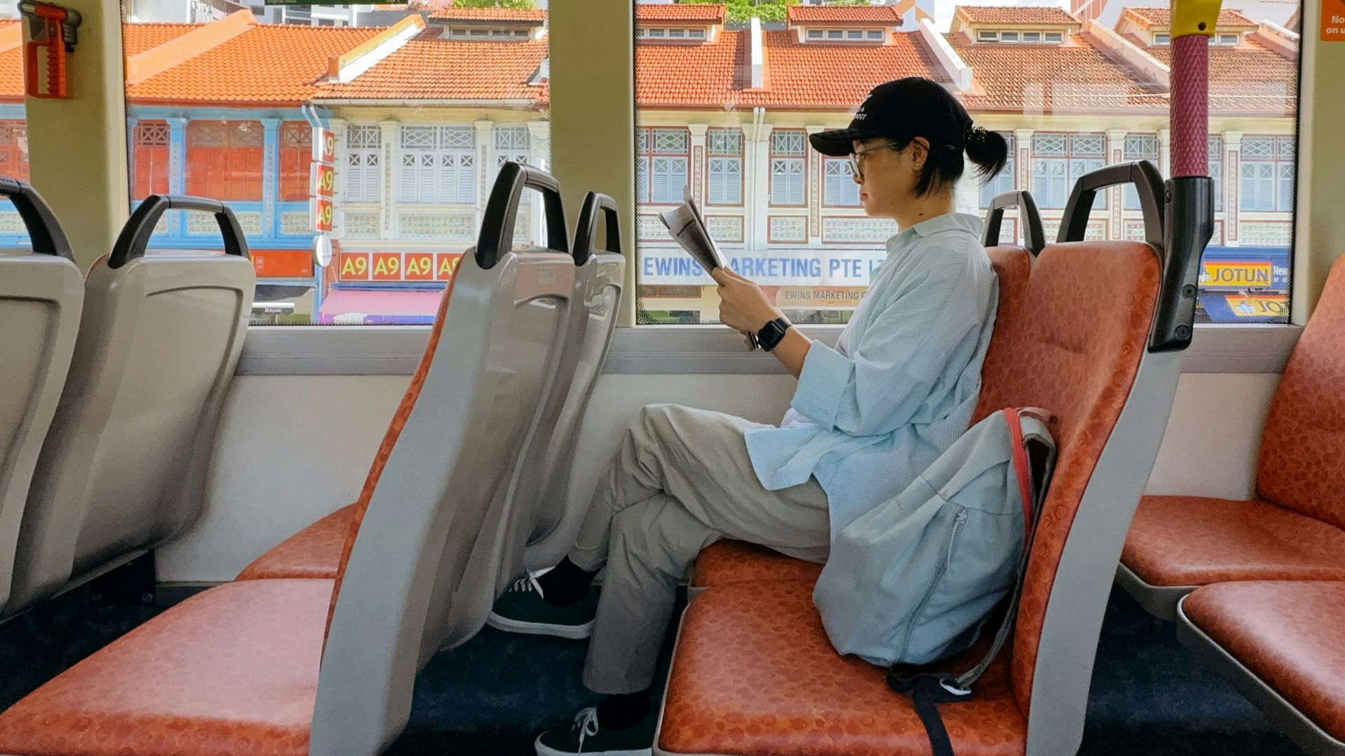 Person reading a book on a bus