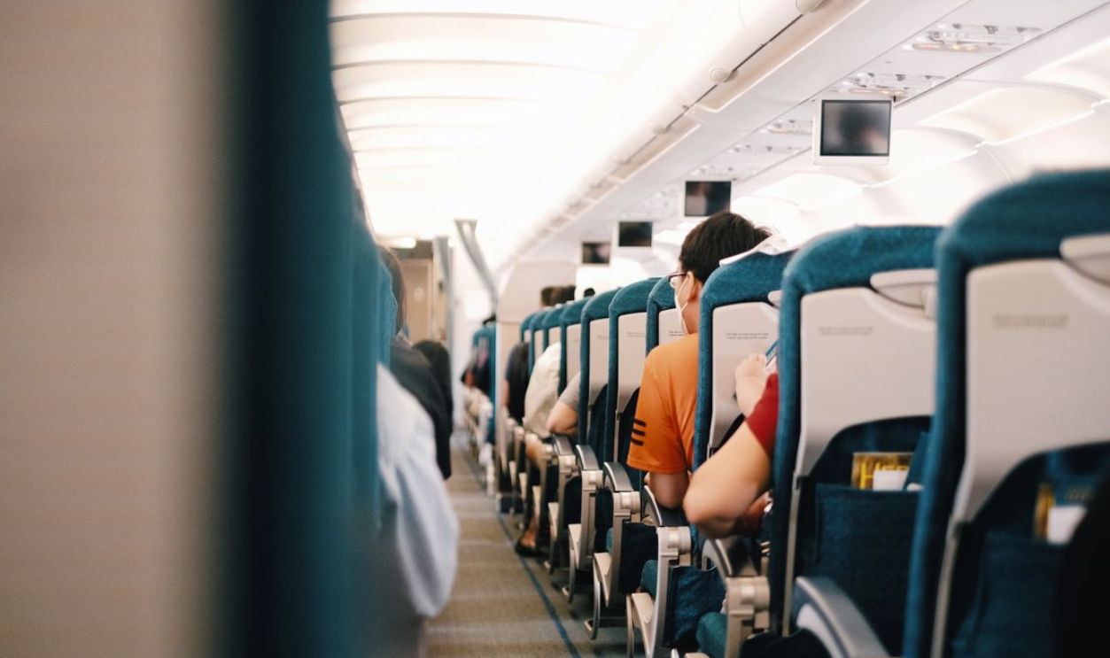 Interior view of airplane cabin showing passengers seated during a flight.