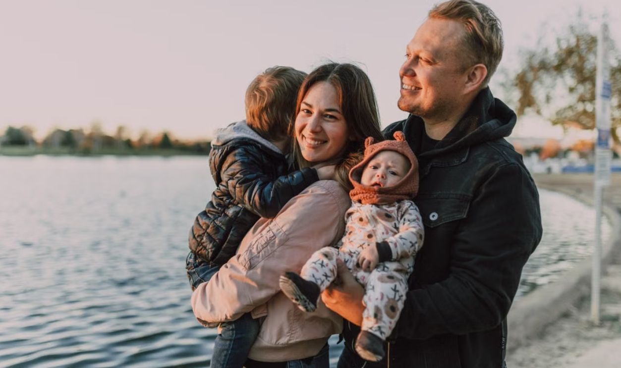 A joyful family with children enjoying a sunset by the lake, capturing love and togetherness