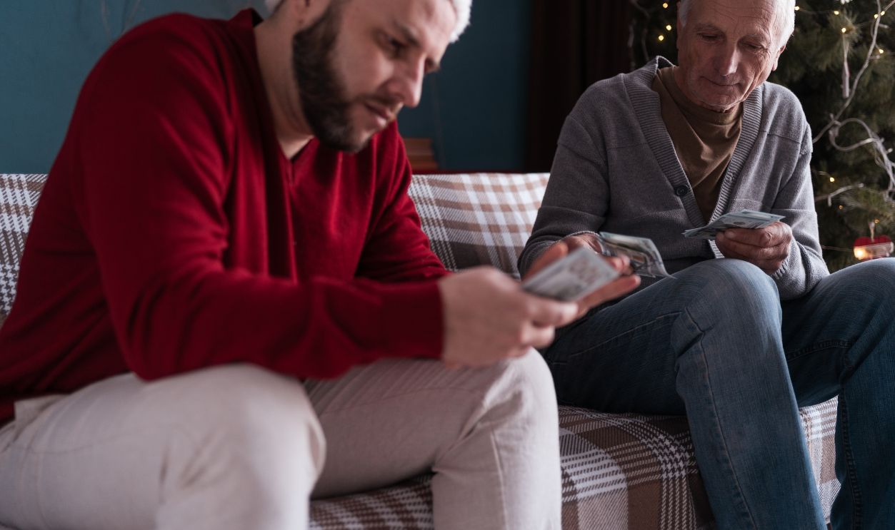 Retired man lends money middle-aged son to helps deal with financial problems on Christmas eve. Copy space