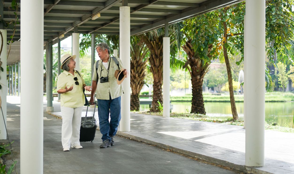 Asian senior couple traveler with luggage walking in downtown
