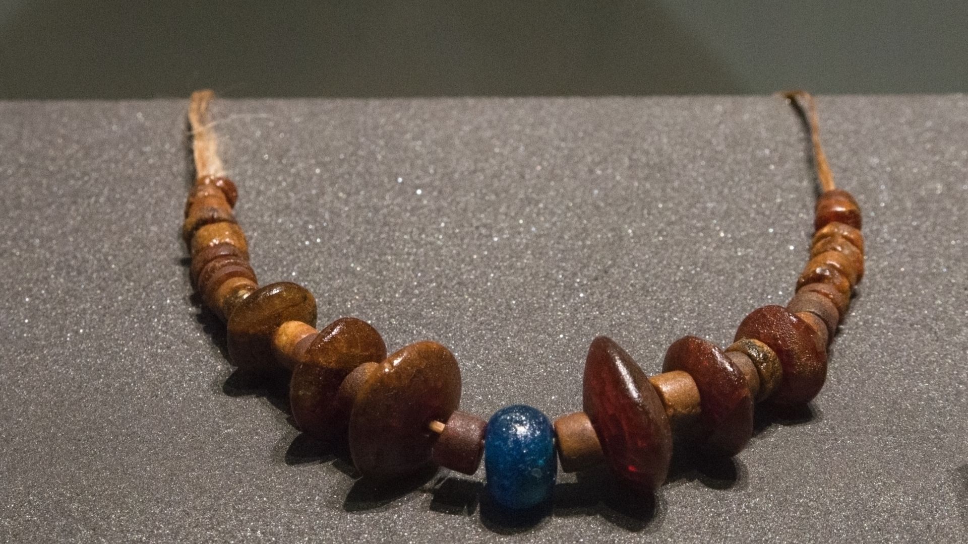 Necklace made of amber beads with a central blue glass bead. Found at Všekary-Husté Leče (Domažlice District), tumulus 2, Middle Bronze Age. Museum of Western Bohemia in Pilsen.