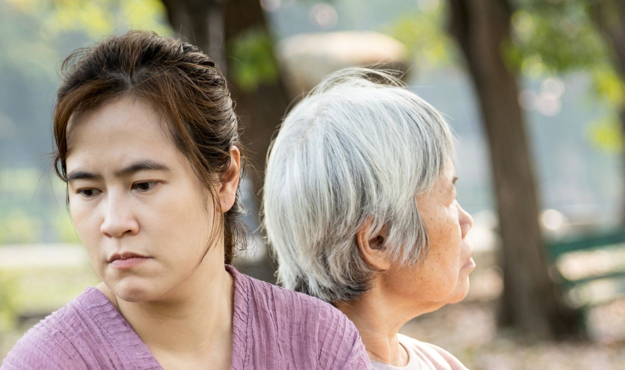 Displeased asian daughter sitting back to back after quarrel,argue feel offended,slighted with upset senior mother in outdoor park,relationship difficulties,conflict,family crisis,lifestyle problems