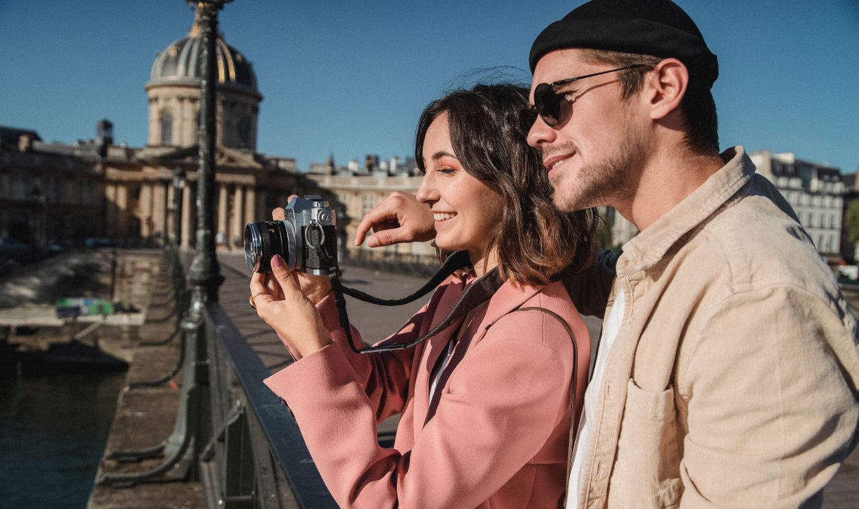 Couple enjoying photography on a Parisian bridge