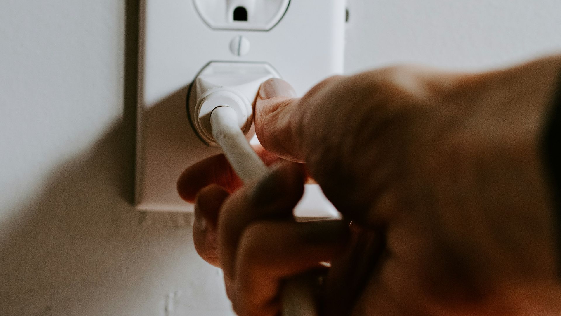 person holding white electric plug