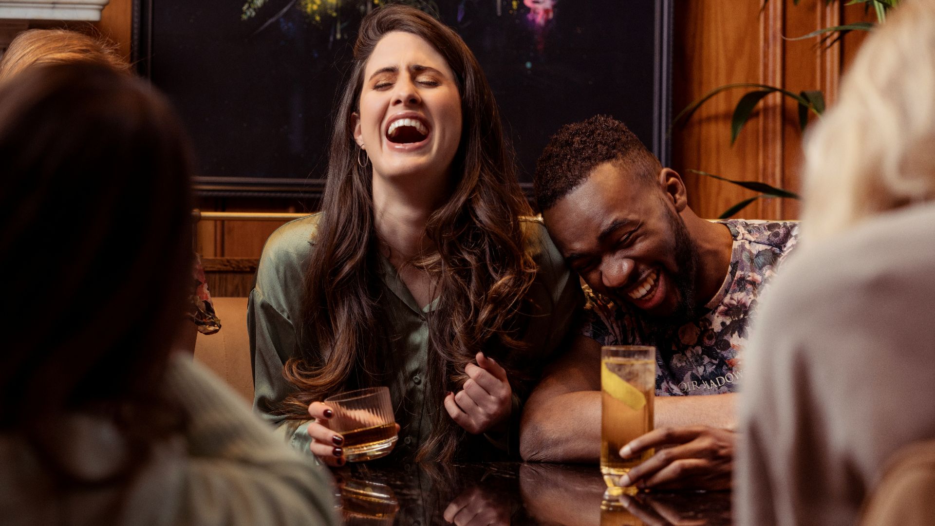 a group of people sitting around a table laughing