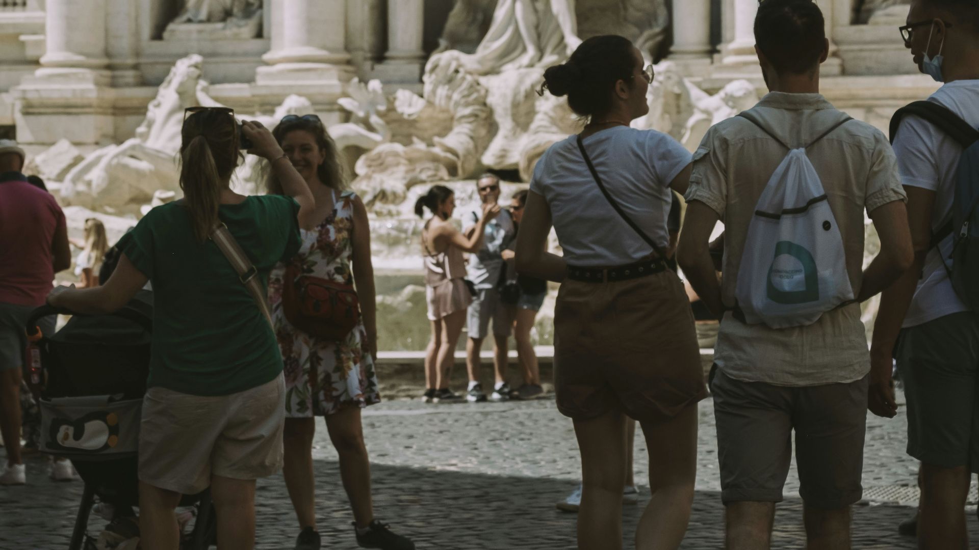 people walking on street near statue during daytime