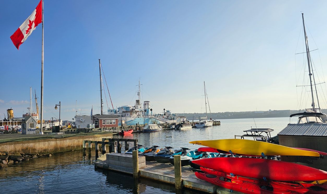 Halifax, NS, CAN, August 13, 2023 - Vessels and kayaks docked along the wharf at the Halifax, Nova Scotia waterfront as the sun rises in the morning.