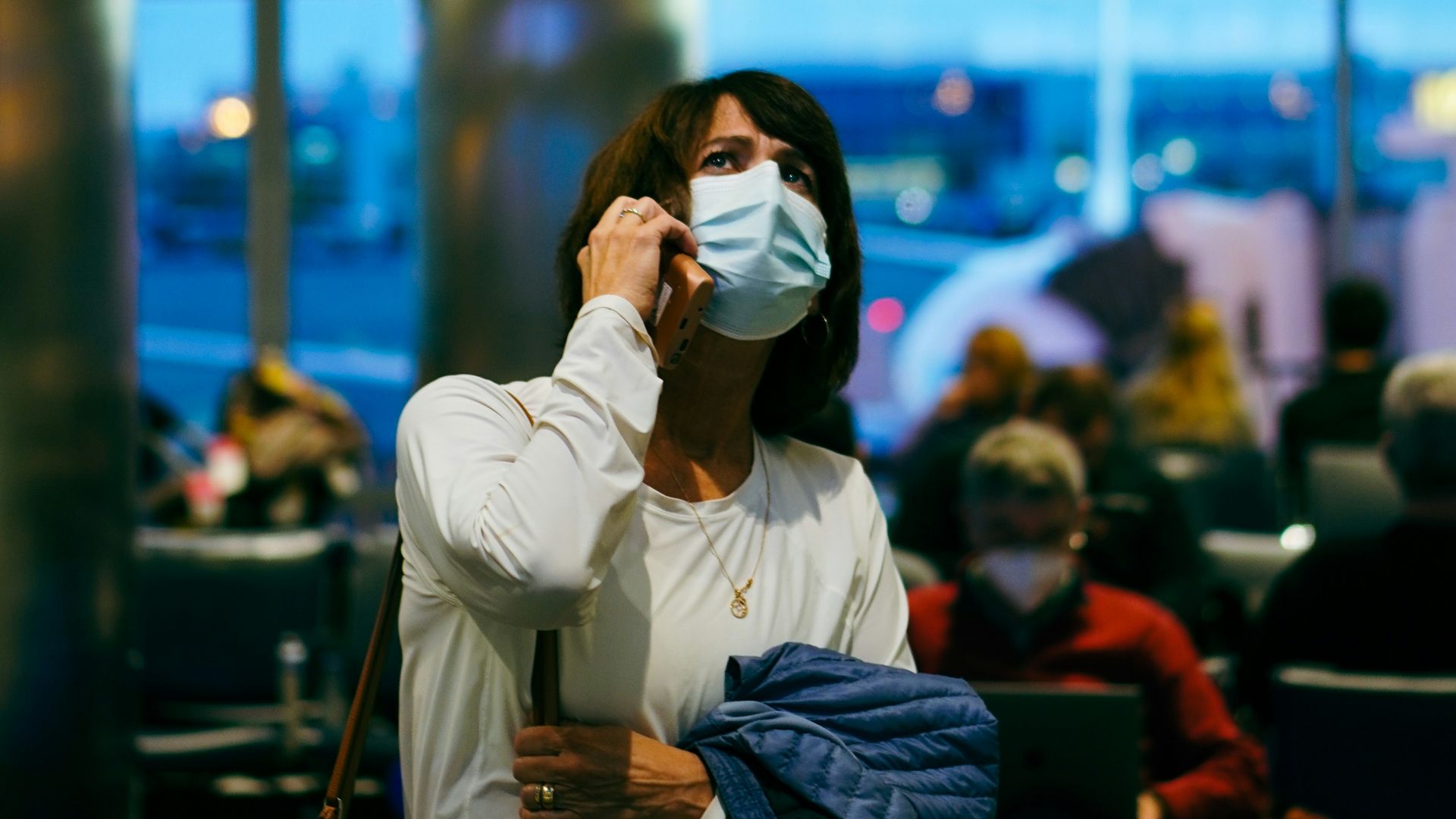 a woman wearing a face mask at an airport