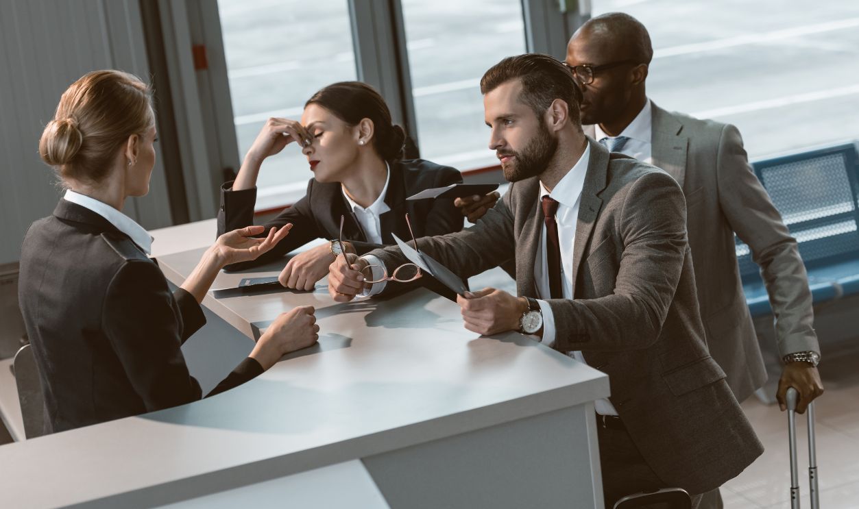1007294374 - group of angry businesspeople having argument with airport receptionist