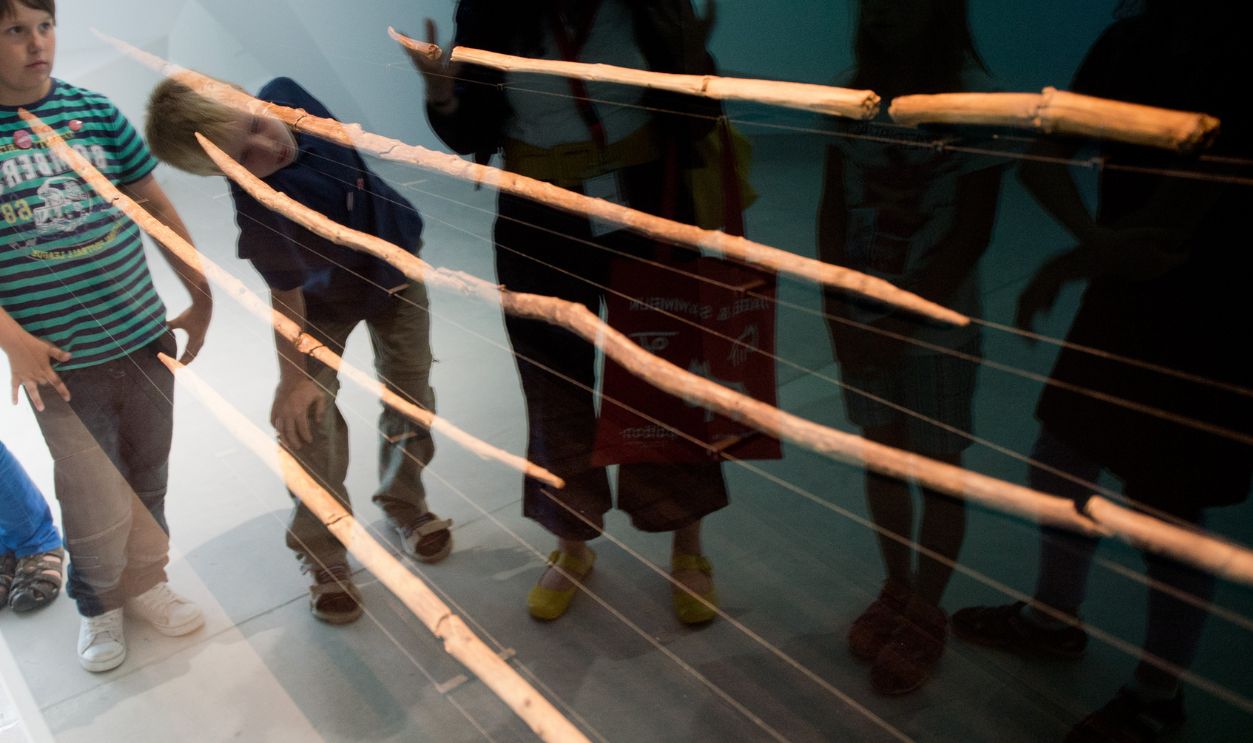 School children stand in front of the Schoeningen Spears at the Exhibit and Research Centre Palaeon in Schoeningen, Germany, 24 June 2013. The 15 million euro project was officially opened on 24 June 2013. The oldest completely preserved hunting weapons in the world, the Schoeningen Spears, will be on display at the centre nineteen years after they were found in the open-cast lignite mine Schoeningen