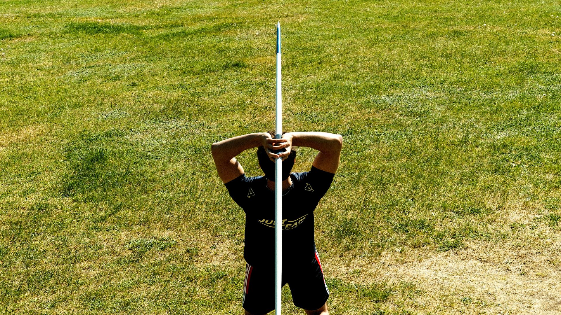 Person holding a tall white pole outdoors