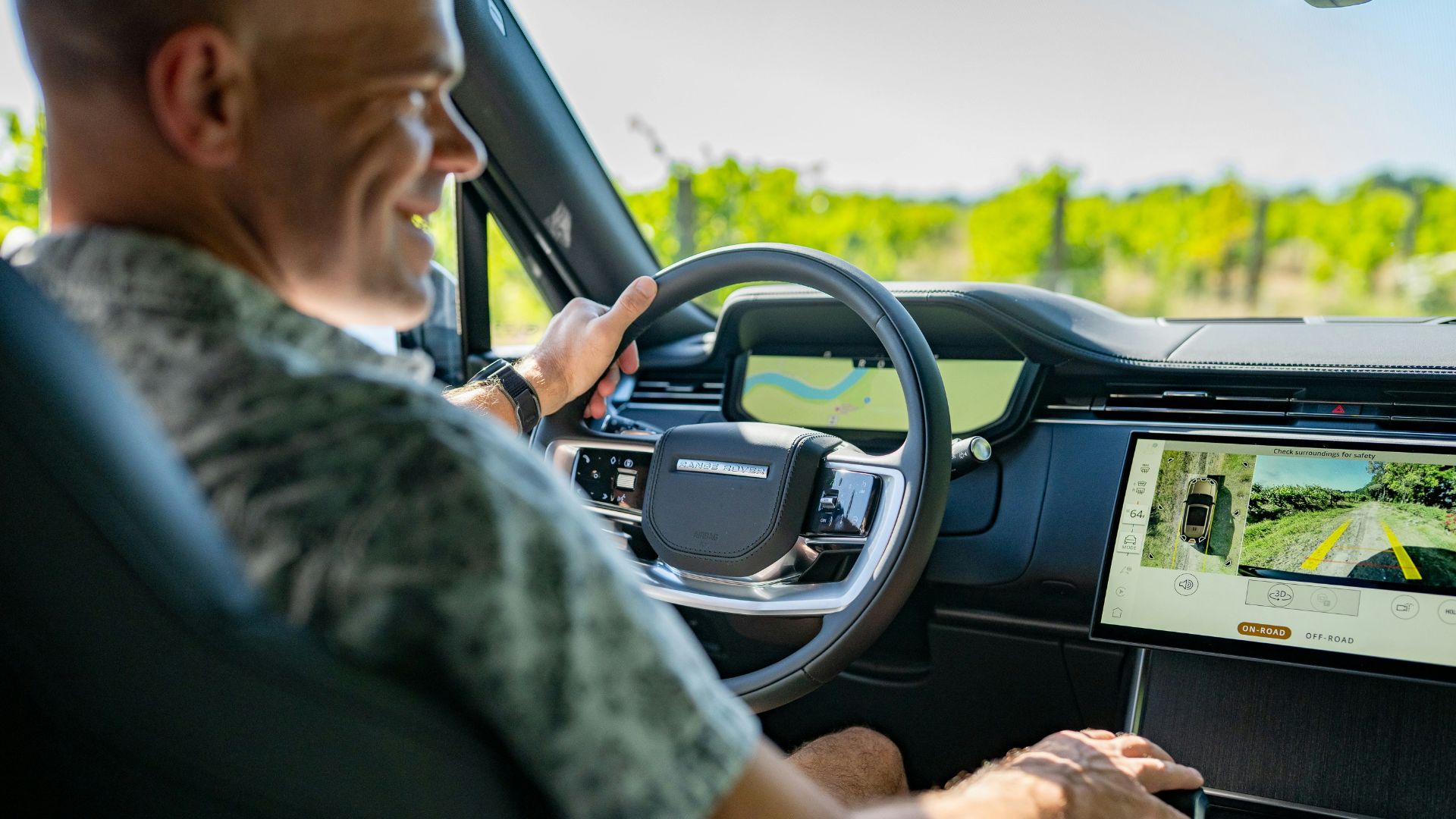 Man driving a modern car through a vineyard