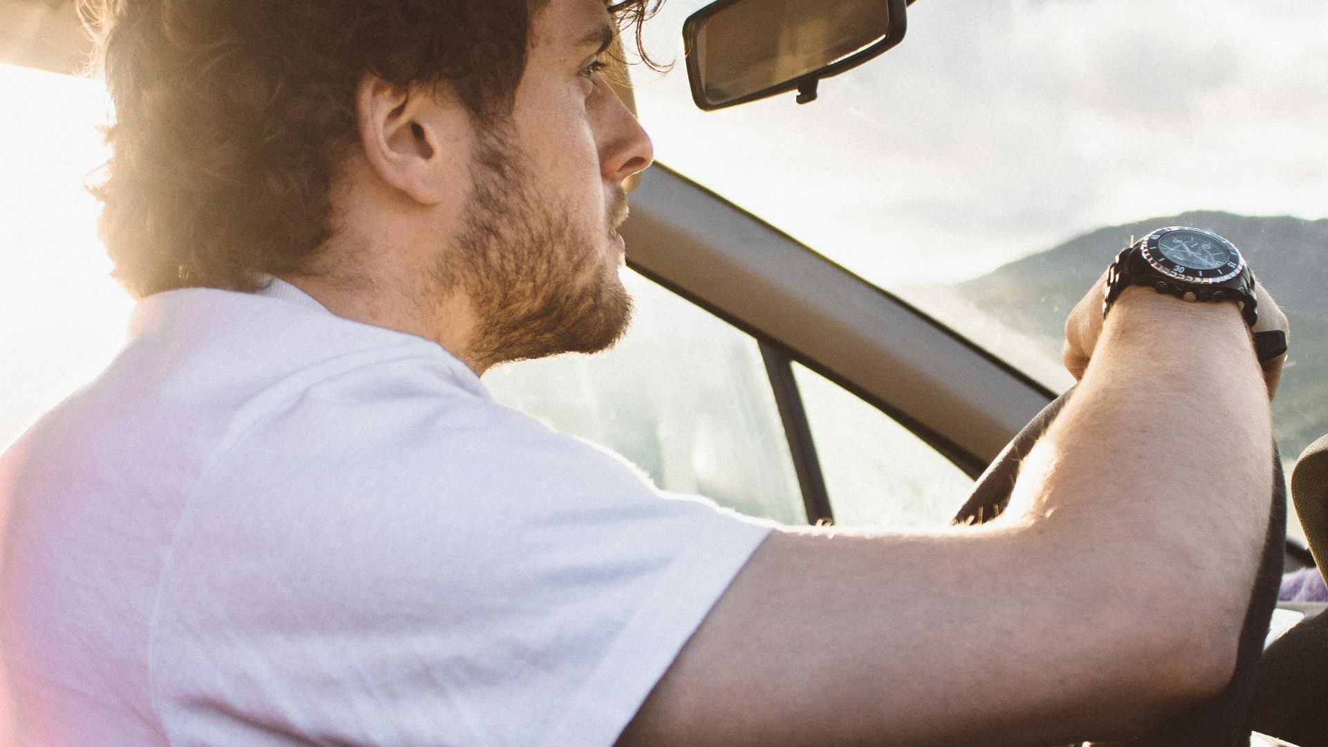 man holding steering wheel