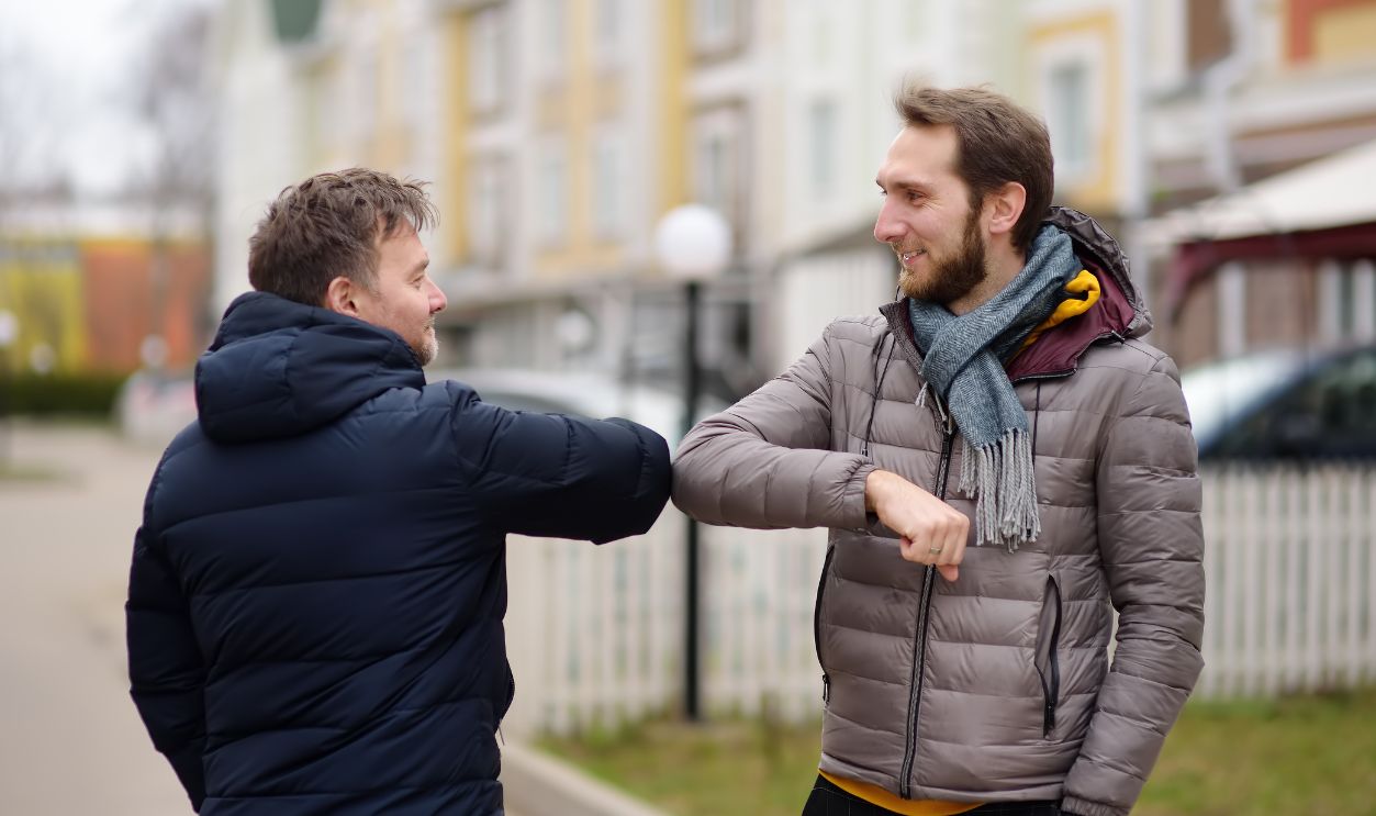 Men greeting each other with elbows instead of handshake. Friends colleagues touch elbows . Alternative non-contact greeting during coronavirus epidemic. Safety while COVID-19. Outbreak of Sars-cov-2