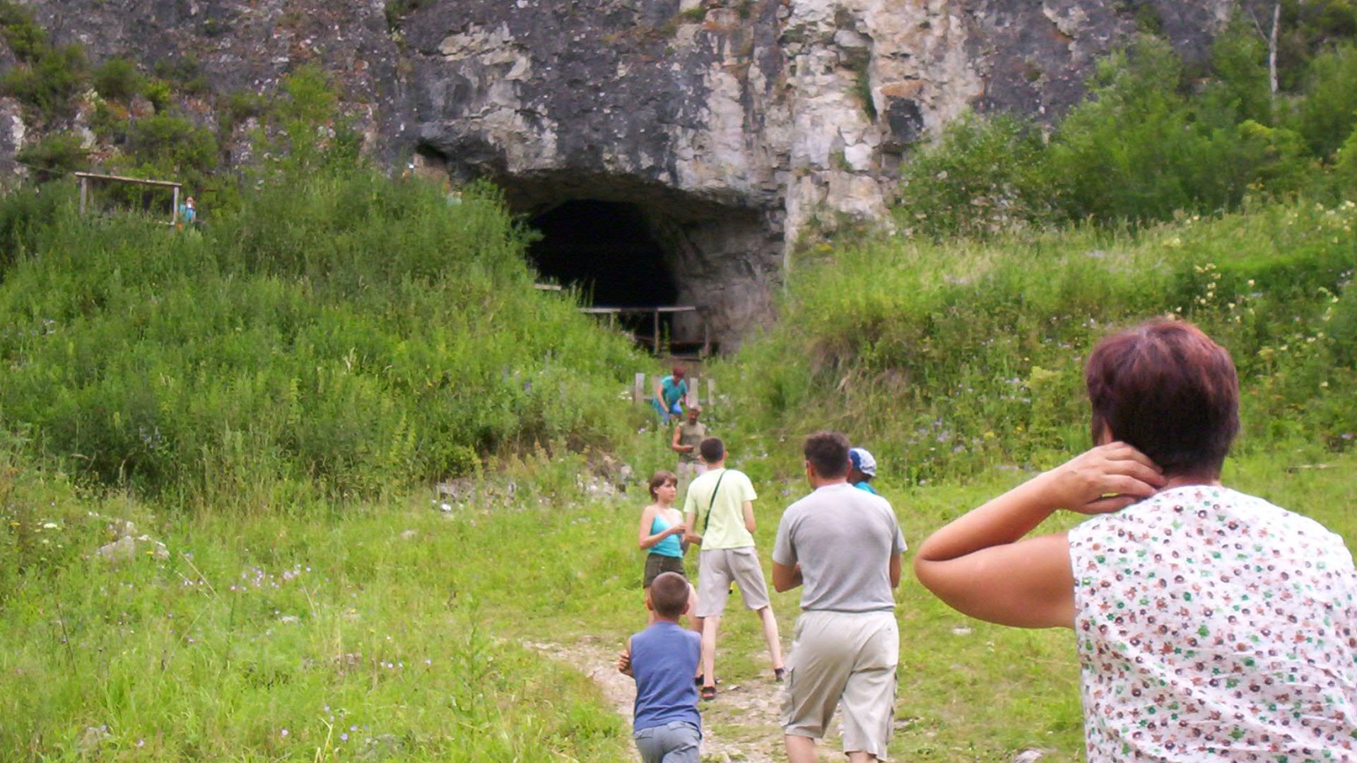 Tourists at the entrance to Denisova Cave, Russia