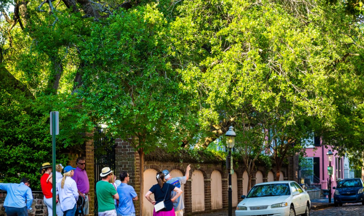 Charleston, USA - May 12, 2018: South Carolina Southern Downtown old town French quarter city with people on guided walking tour on cobblestone residential street road