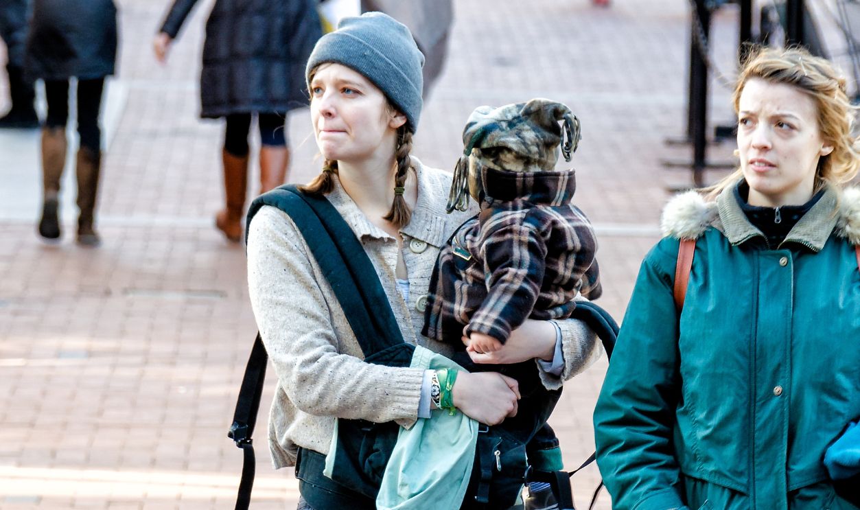 Charlottesville, USA - January 10, 2015: Two twin sisters, women, walking in downtown Main Street mall in Virginia with one woman holding kid, baby, toddler, child in arms, hands
