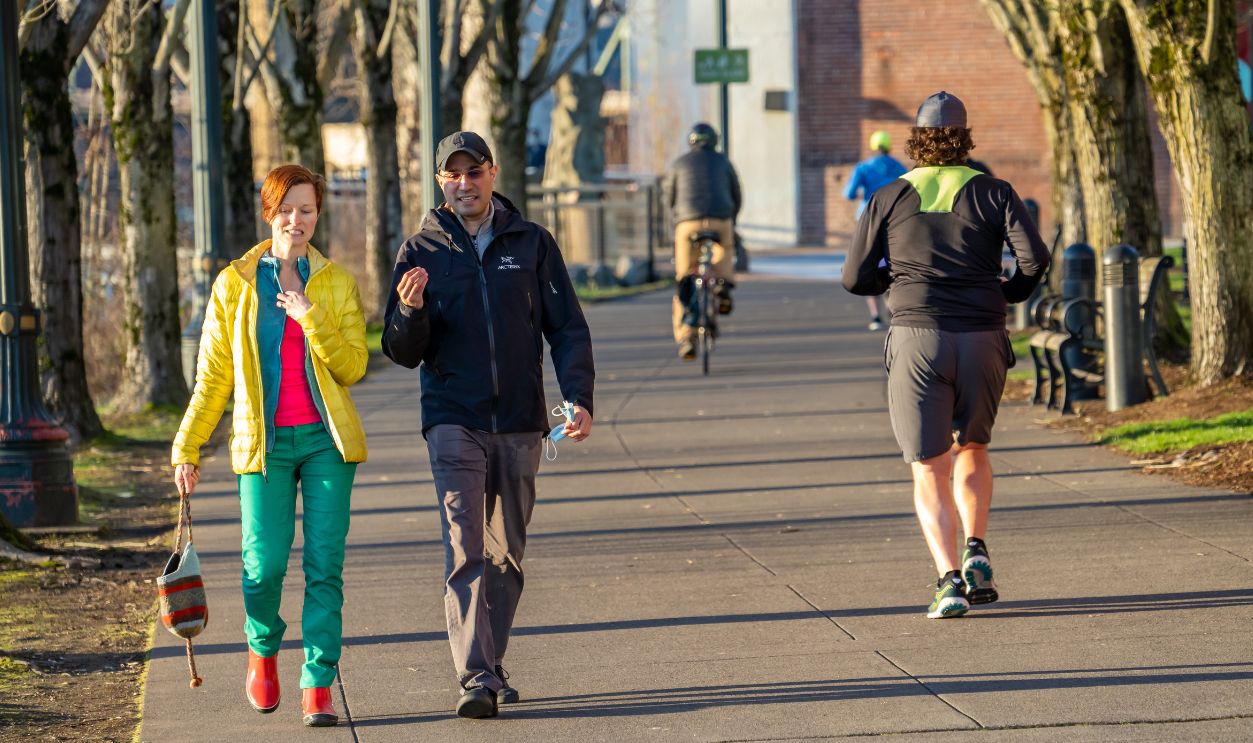 Portland, Oregon - 2-11-2021: a man and woman walking on the pedestrian bicycle path on the east shore of the Willamette River in Portland Oregon