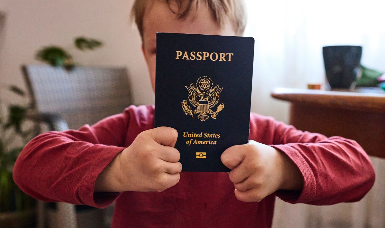 Happy smiling young female traveler holding USA passport at airport
