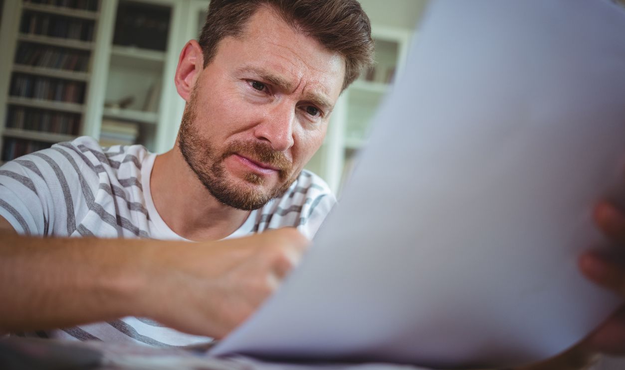 Worried man looking at his bills at home