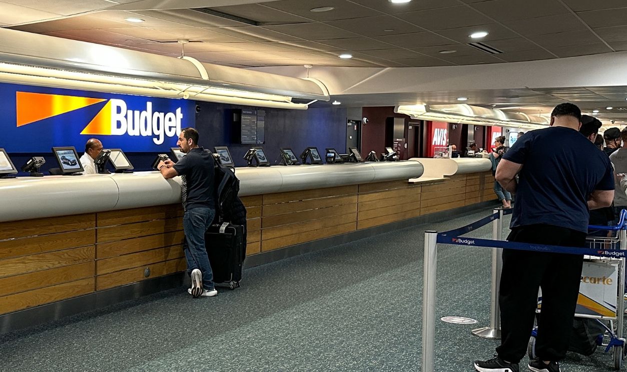 Detroit, Michigan, USA - 4 May 2025: Travelers wait in line at the Budget car rental counter inside Detroit Metropolitan Wayne County Airport