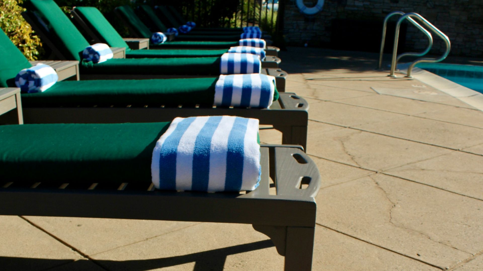 Lounge chairs with towels by a swimming pool