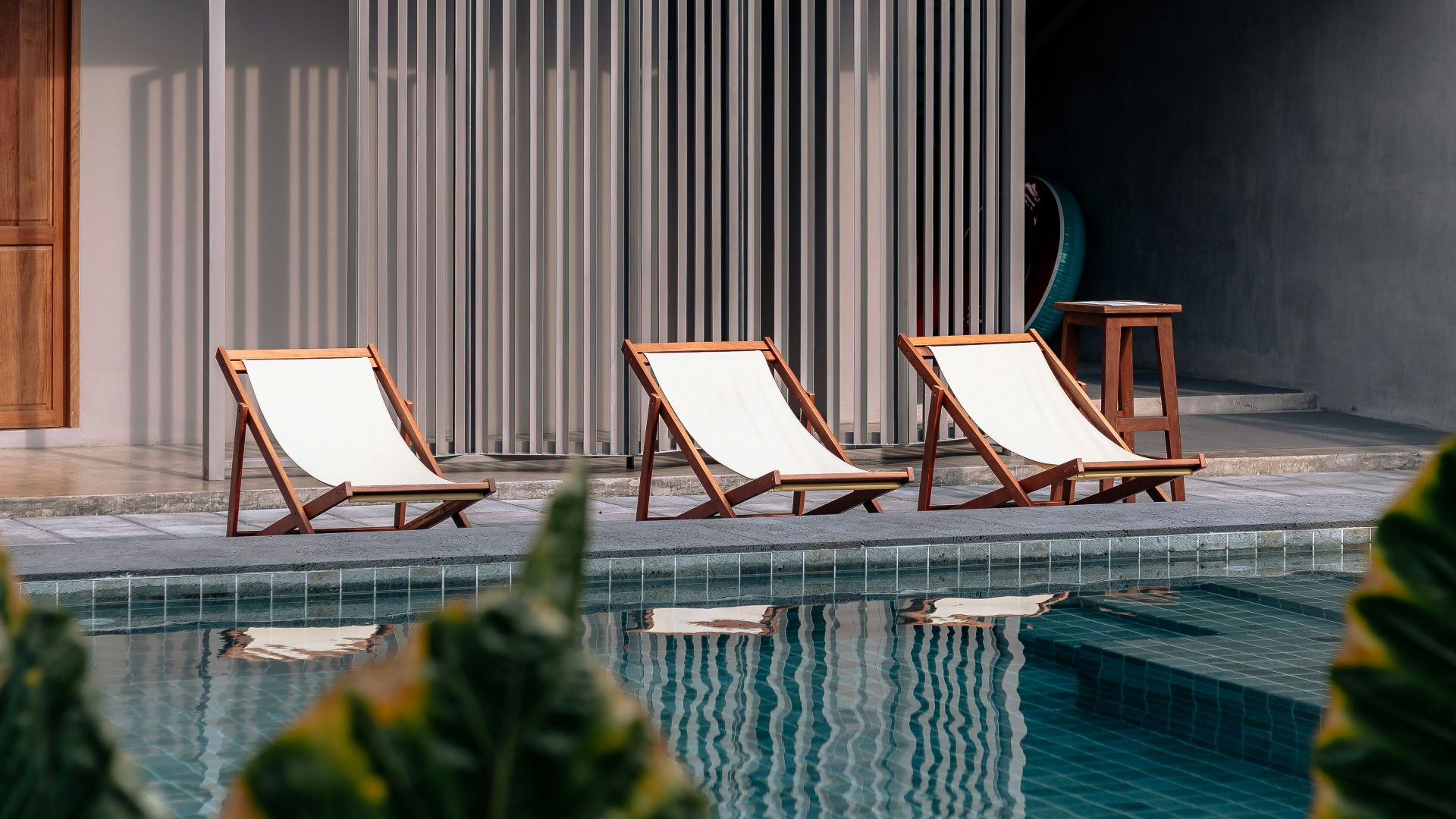 three white-and-brown wooden pool chairs