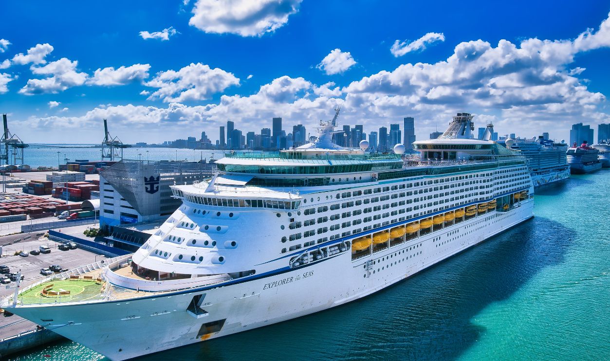A luxurious cruise ship moored at the bustling Miami port with the city skyline in the background