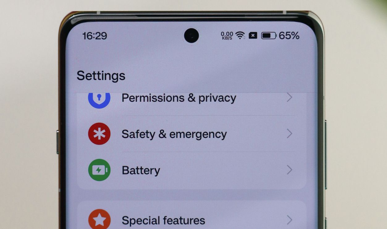 Close-up of a smartphone screen displaying settings menu options like privacy and battery.