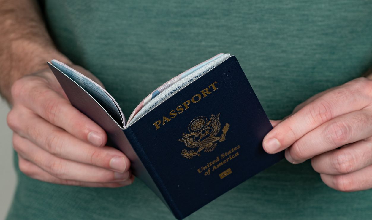 Charlotte, NC - May 3, 2022: Adult male holds a US Passport book with a shallow depth of field and copy space