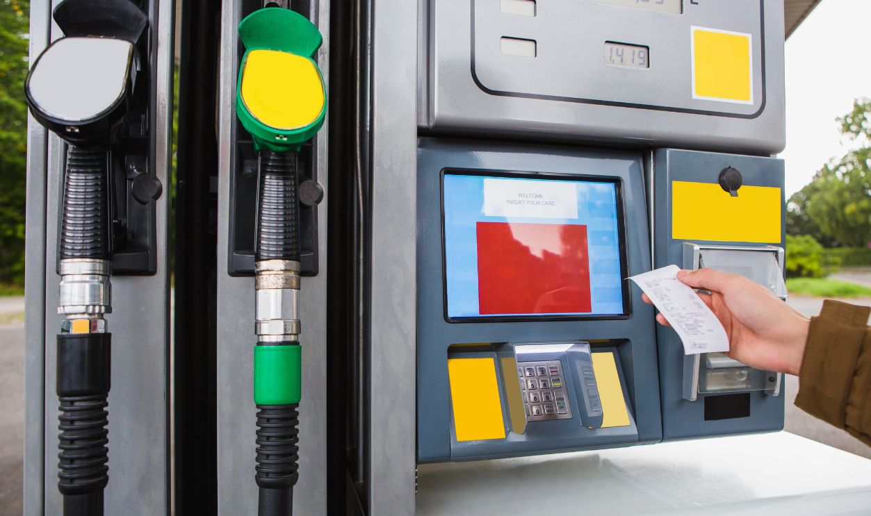 Self-service filling station. The man is holding a receipt in his hand.