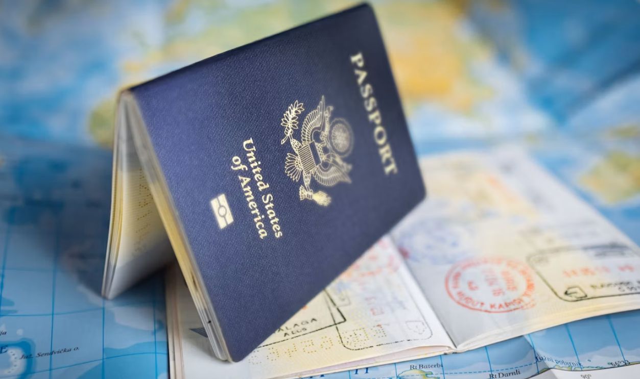 A United States passport resting open on a colorful world map